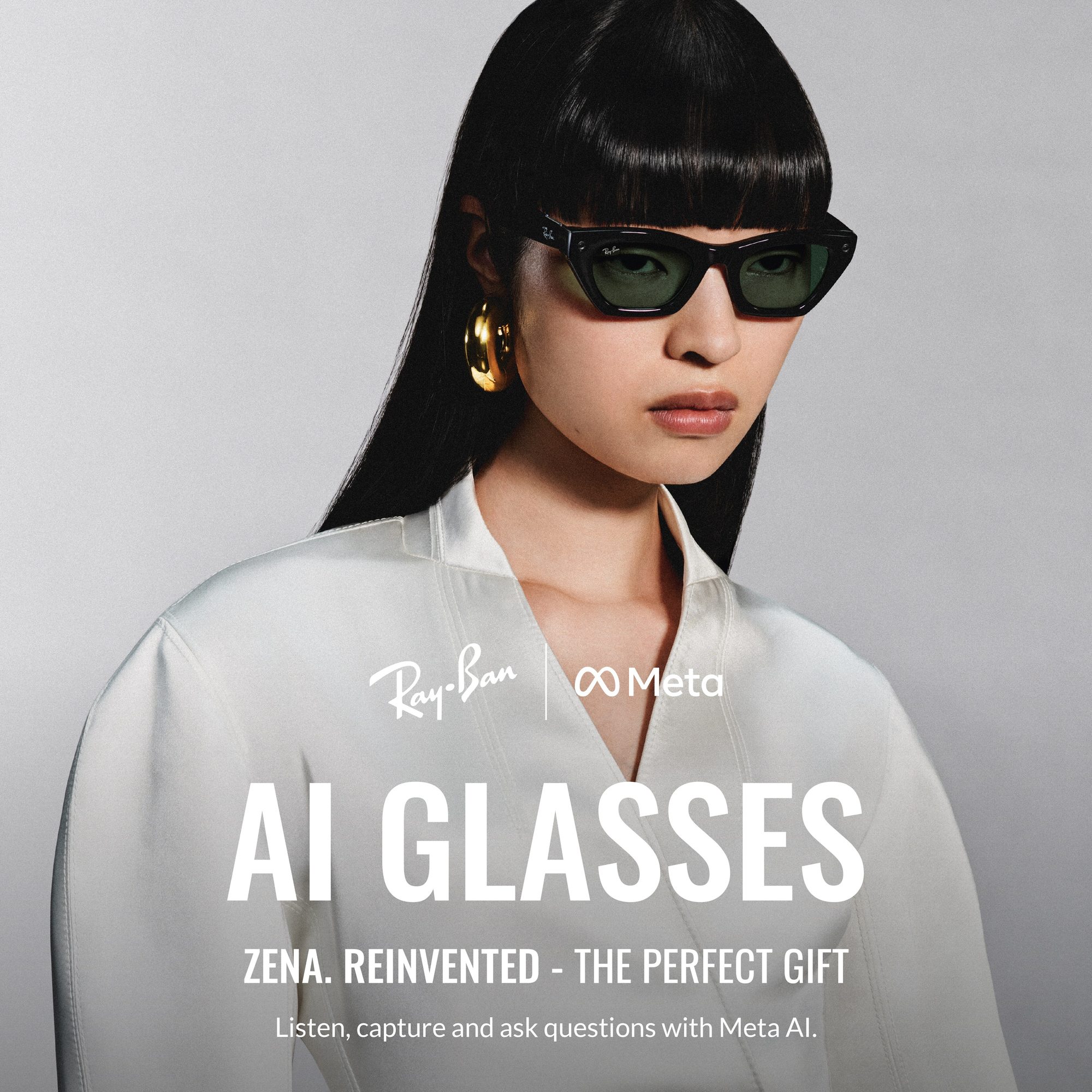 Donna con occhiali da sole neri wayfarer, orecchini dorati e camicia bianca su sfondo grigio